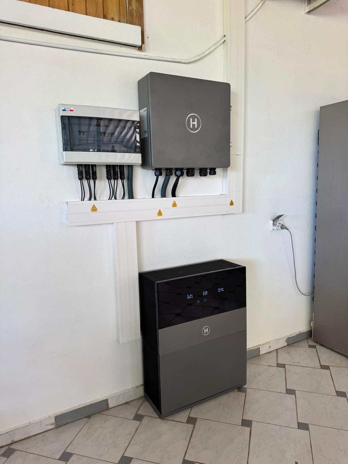 Onduleur hybride, coffret de protection et batterie installés dans un local technique par FRH Guadeloupe
