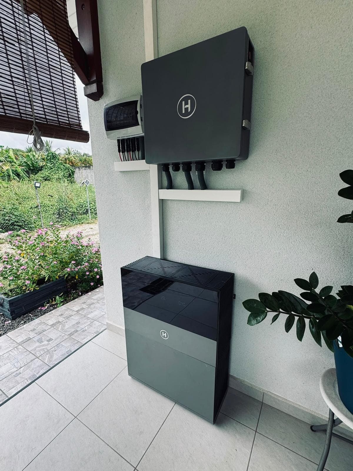 Onduleur hybride et batterie posés sur une terrasse couverte par FRH Guadeloupe