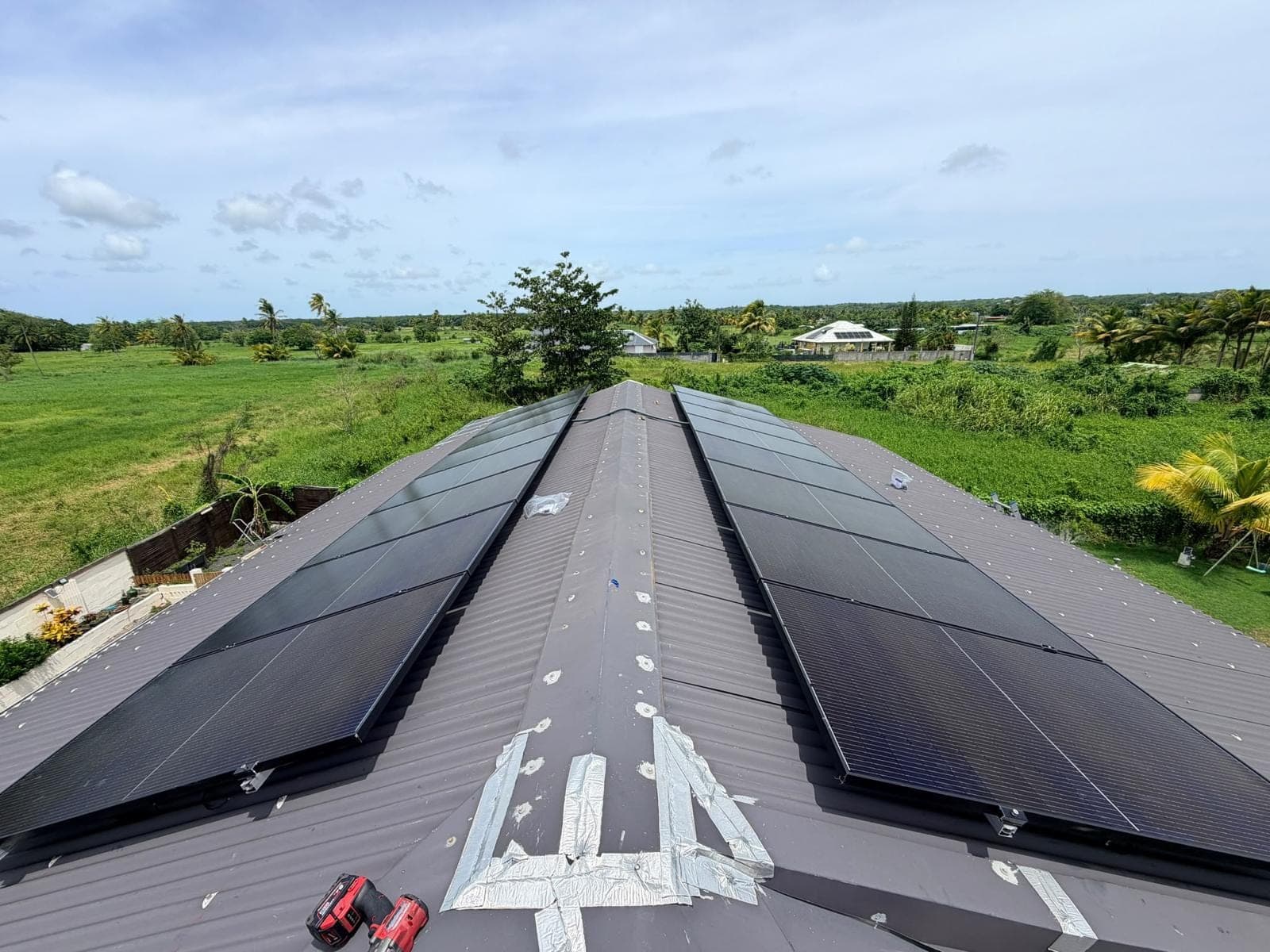 Panneaux solaires sur les deux pans d’une toiture en tôle, de part et d’autre du faîtage, Guadeloupe